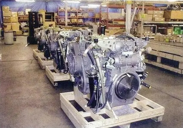 A row of engines sitting on top of pallets.