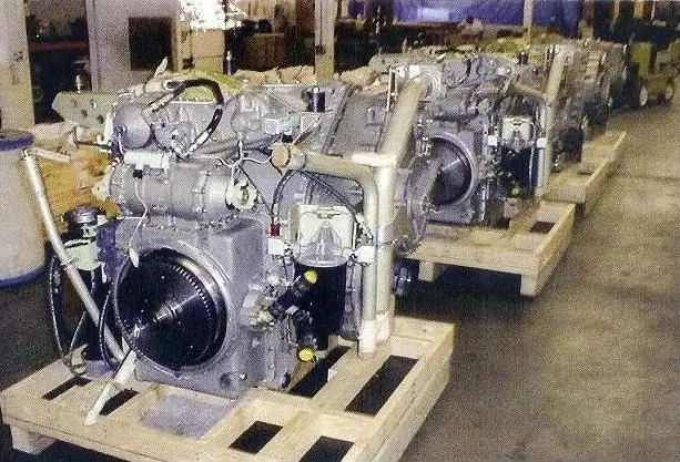 A row of engines sitting on pallets in a warehouse.